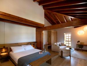 a bedroom with a large bed and a couch at Otegui Etxea Casa Rural in Aspuru