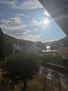 a view from a window of a city with the sun in the sky at Ferienwohnung Salzwiese in Brodenbach +3 photos