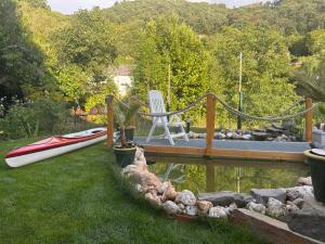 a deck with a chair and a boat on the water at Ferienwohnung Salzwiese in Brodenbach