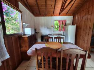 a kitchen with a table and chairs and a refrigerator at Cabanas Areias in Praia do Rosa