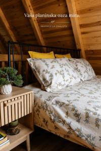 a bedroom with a bed with a wooden ceiling at Javorje24 chalets in Žabljak