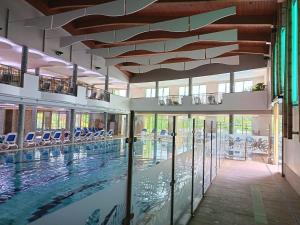 a swimming pool in a building with glass doors and a swimming pool at alma713 apartman in Zalakaros