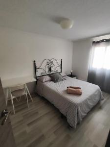 a bedroom with a bed and a desk and a window at Alojamiento cerca de la Playa in Valencia