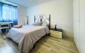 a bedroom with a large bed and a table at Alojamiento cerca de la Playa in Valencia