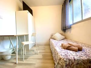 a bedroom with a bed and a desk and a window at Alojamiento cerca de la Playa in Valencia