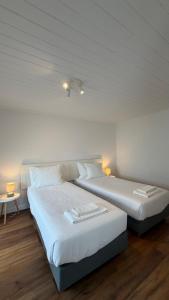 two beds sitting next to each other in a room at Refúgio das Marés in Ponta Delgada