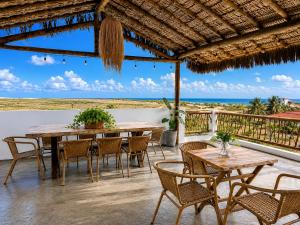 a patio with tables and chairs and the ocean at The Wave Kite House in Guriú