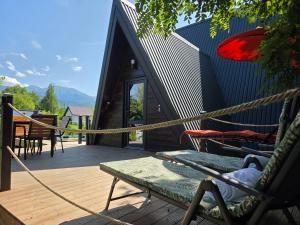 a house with a hammock on a wooden deck at Api Chalet in Avrig