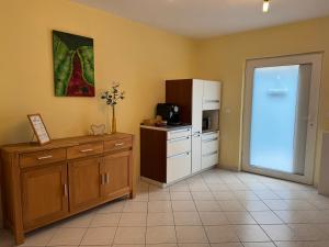 a room with a kitchen with a refrigerator and a counter at Ferienwohnung Naunheim, ebenerdig, Smart TV in Wetzlar +5 photos