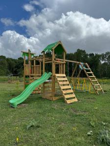 a wooden play set with a slide and a slideintend at Les nids de la chevêche in Saint-Pierre-de-Juillers
