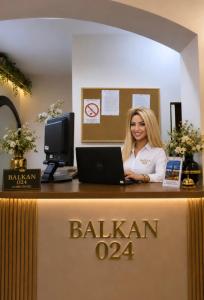 a woman standing at a desk with a laptop at Balkan 024 in Subotica