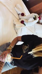 a woman laying on a bed with a glass of wine at Balkan 024 in Subotica