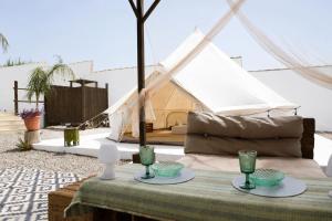 a tent with a table with glasses on it at CALMA TIPI Glamping con piscina en Chiclana in Chiclana de la Frontera