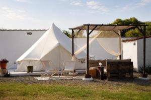 a large white tent with chairs and a table at CALMA TIPI Glamping con piscina en Chiclana in Chiclana de la Frontera