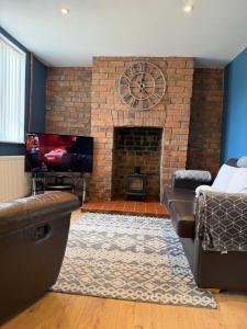 a living room with a brick fireplace and a couch at Beautiful mid wales cottage in Garth