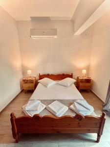 a bedroom with a wooden bed with two night stands at Nancy in Politika +57 photos