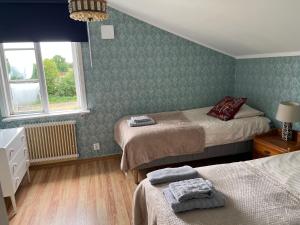 a small bedroom with two beds and a window at Per Larsgård in Veddige +5 photos