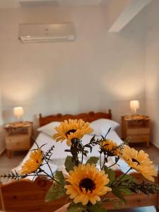 a vase of yellow flowers on a table in a bedroom at Nancy in Politika