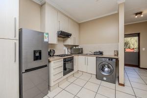 a kitchen with a refrigerator and a washing machine at Grace Haven in Sandton