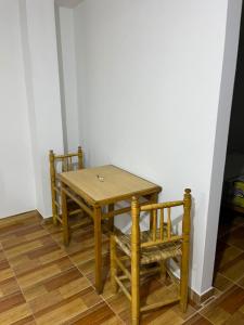 a wooden table and two chairs in a room at Las Lomas Hotel in Caraz