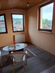 a room with a table and two windows at Apartman Mickey in Sarajevo +13 photos