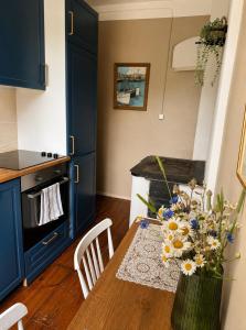 a kitchen with a table with a vase of flowers at Taevaskoja külaliskorter in Taevaskoja