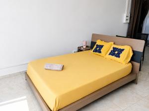 a yellow bed with yellow pillows and a towel on it at Studio cosy vue sur mer in Mtsamboro