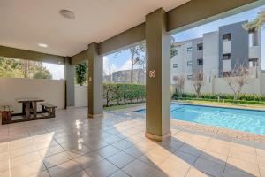 a villa with a swimming pool and a building at Grace Haven in Sandton