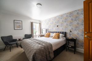 a bedroom with a bed and two chairs at Redesdale Arms in Otterburn