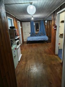 a room with a bed with a blue curtain at MiraMar Casa Azul in Puerto Saavedra
