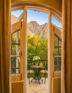 a balcony with a table and a view of mountains at Vale Montis Near Dal Lake Srinagar in Srinagar