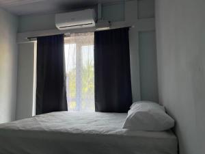 a bedroom with a bed with a window and a pillow at Monarca Village in La Libertad +5 photos