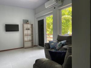 a living room with a couch and a tv at Monarca Village in La Libertad