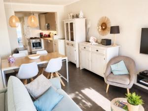 a living room with a couch and a table with chairs at De Zandkorrel - Amazing seaview in Wenduine