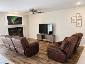 a living room with two leather chairs and a flat screen tv at Cozy Tampa Home in Tampa