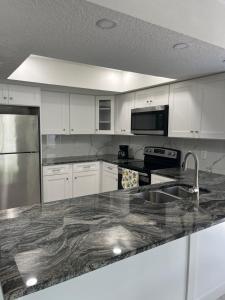 a kitchen with white cabinets and a granite counter top at Cozy Tampa Home in Tampa