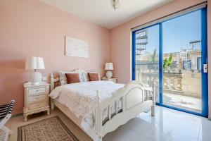 a bedroom with a white bed and a large window at Il-Kannizzata luxurious Gozo penthouse with sea view & pool in Għajnsielem +71 photos