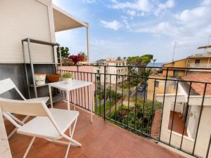 a balcony with two chairs and a table and a view at il grippiale in Aci Castello