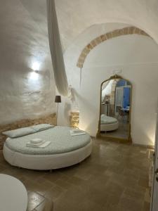 a bedroom with a large bed and a mirror at Arquati Suite Luxury Apartment in Ostuni