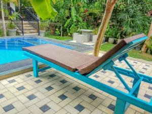 a lounge chair next to a swimming pool at White Villa Goyambokka - Private Pool Villa in Tangalle