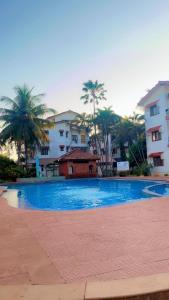 a large blue swimming pool in front of some buildings at Shiva Valley Retreat in Calangute
