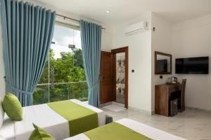 a bedroom with two beds and a large window at Sunset Heaven Boutique in Kandy