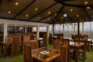 a restaurant with wooden tables and chairs with a view at Sunset Heaven Boutique in Kandy