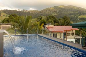 a swimming pool with a water fountain in front of a house at Sunset Heaven Boutique in Kandy
