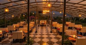 a restaurant with tables and chairs on a checkered floor at Vale Montis Near Dal Lake Srinagar in Srinagar
