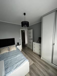 a bedroom with a bed and a large window at Apartament w Dolinie Baryczy in Milicz