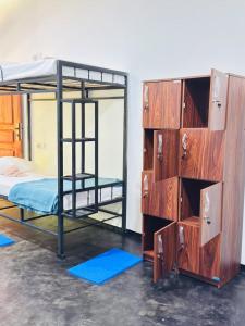 a bedroom with two bunk beds and a dresser at Glowhaven Hostel in Sigiriya
