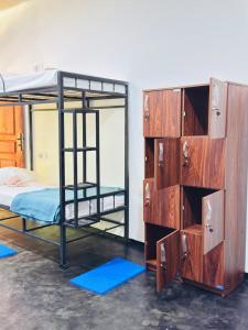 a room with two bunk beds and a dresser at Glowhaven Hostel in Sigiriya +11 photos
