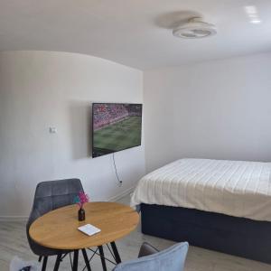 a bedroom with a bed and a wooden table and chairs at Modern Studio Nagórki in Olsztyn