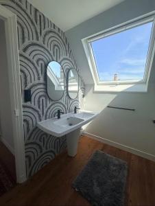 a bathroom with a sink and a window and a mirror at La Côte in Granville +27 photos